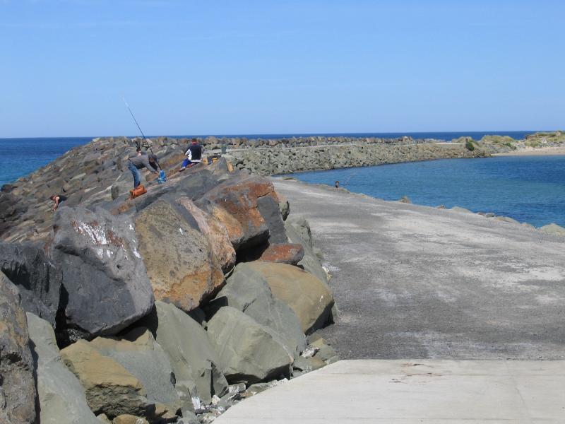 Apollo Bay - Boat Harbour, wharf and breakwater: People fishing on the breakwater