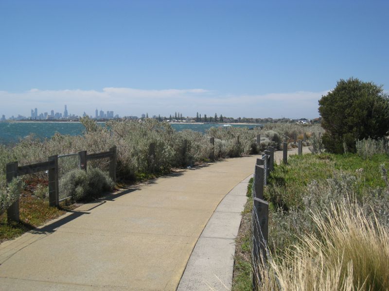 Brighton - Beach and coastline between North Road and Middle Brighton Pier: Northerly view along coastal pathway towards city skyline
