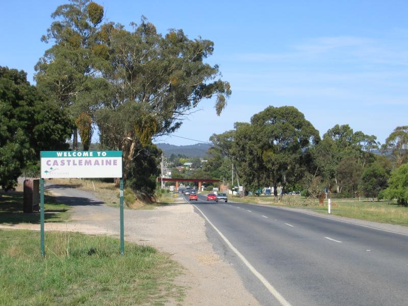 Castlemaine - Western outskirts of Castlemaine: Welcome to Castlemaine sign, view east along Pyrenees Hwy towards railway bridge