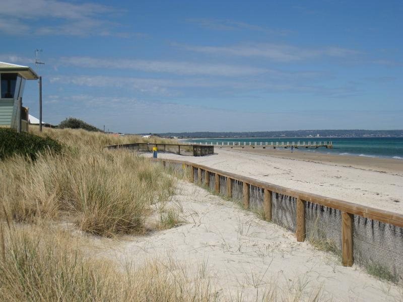 Chelsea - Beach and foreshore around pier and north of pier: View south along beach towards surf life saving club and pier