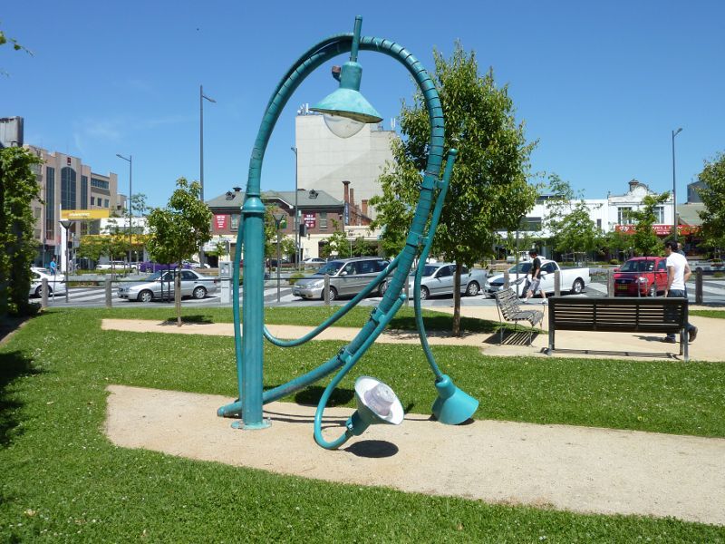 Dandenong - Shops and commercial centre, Lonsdale Street: 'The Utilitarian' fallen lamp sculpture in park linking Lonsdale St and Palm Plaza