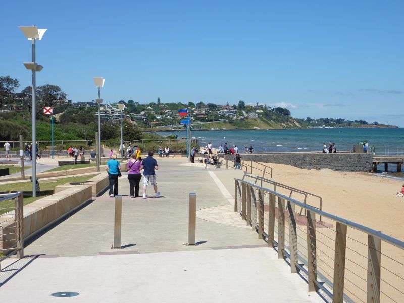 Frankston - Frankston Waterfront and Frankston Pier, Pier Promenade: View from entrance to Landmark Bridge along beach towards pier