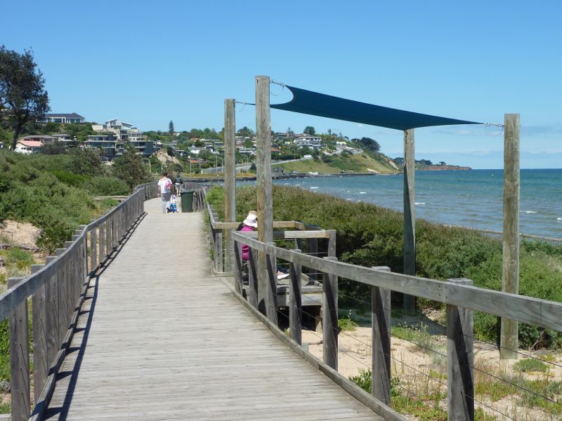 Frankston - Foreshore boardwalk and beach south of Frankston Pier: View along boardwalk towards shaded viewing platform
