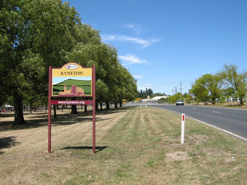 Kyneton - Around Kyneton: Kyneton town sign, view south-east along Burton Av towards Lauriston Rd