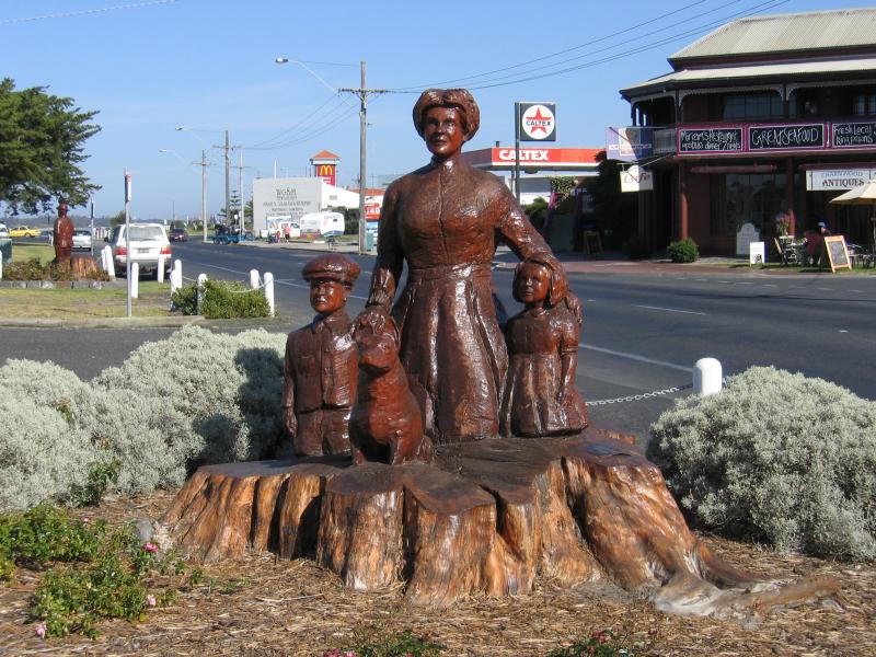 Lakes Entrance - Shops and accommodation along Esplanade: Wooden sculpture, view west along Esplanade at Bulmer St