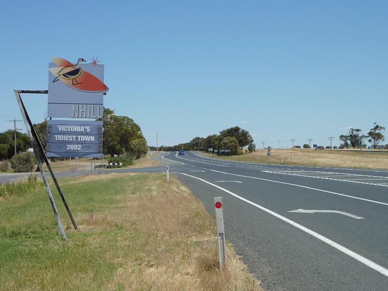 Nhill - Western Highway in Nhill, east of Victoria Street: Nhill town sign, view west along Western Hwy towards Winiam East Rd