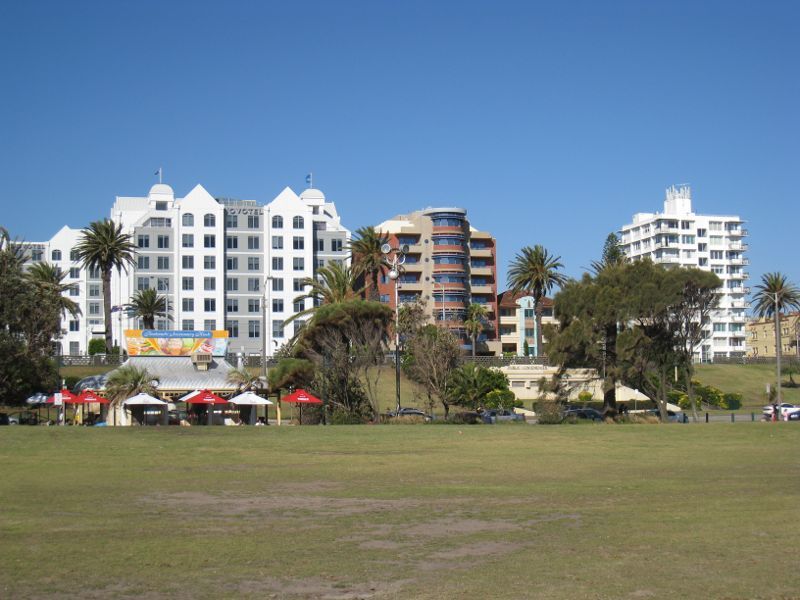 St Kilda - St Kilda Beach, Brooks Jetty and foreshore gardens: View from foreshore lawns towards kiosk and Novotel St Kilda