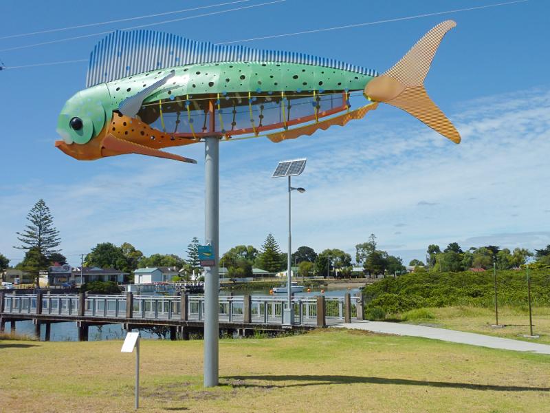 Tooradin - South Gippsland Highway west of town centre: Dolphin fish sculpture near footbridge across Sawtells Inlet