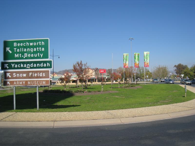 Wodonga - Shops along High Street south of railway line, Stanley Street and Woodland Grove: View south across roundabout at southern end of High St