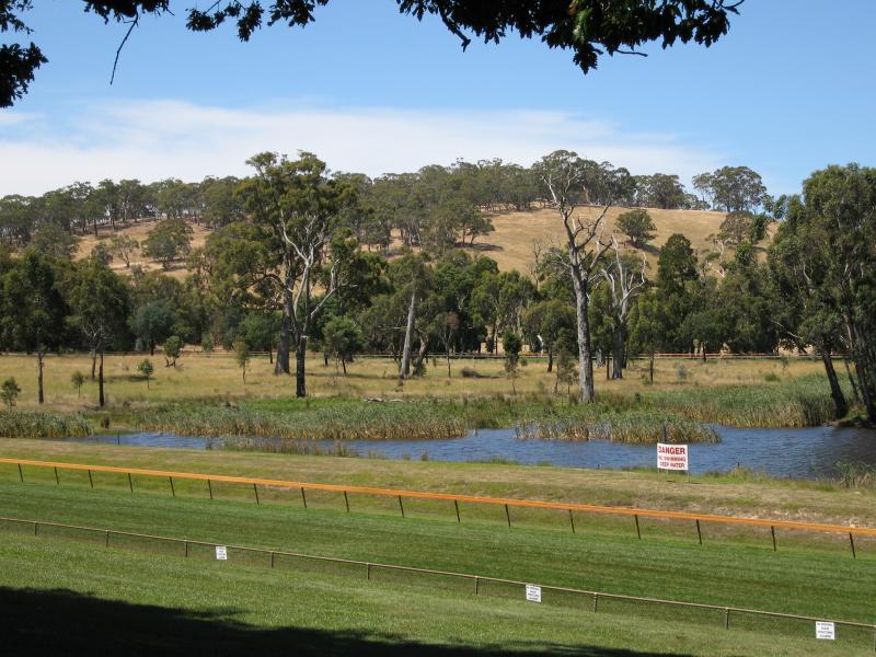 Woodend - Hanging Rock Reserve, South Rock Road: View east across dam in middle of racecourse