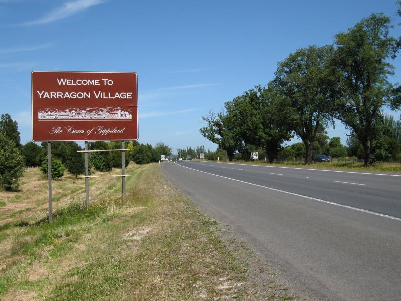 Yarragon - Princes Highway through Yarragon - 'Welcome to Yarragon Village - The Cream of Gippsland' sign, view west along Princes Hwy, eastern edge of town