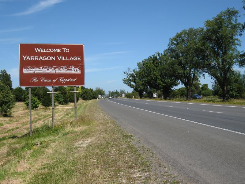 Yarragon - Princes Highway through Yarragon: 'Welcome to Yarragon Village: The Cream of Gippsland' sign, view west along Princes Hwy, eastern edge of town